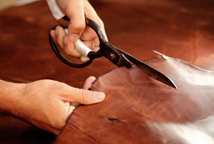 Person Cutting Leather